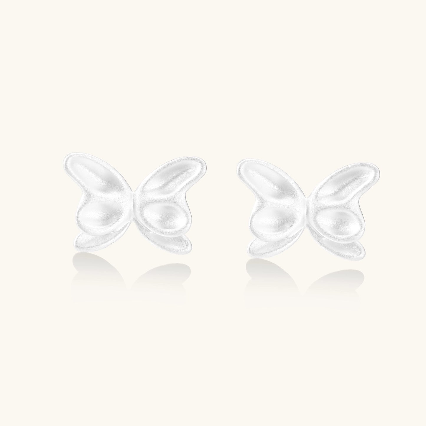Pair of translucent butterfly-shaped stud earrings with frosted finish and dimensional wing details on white background