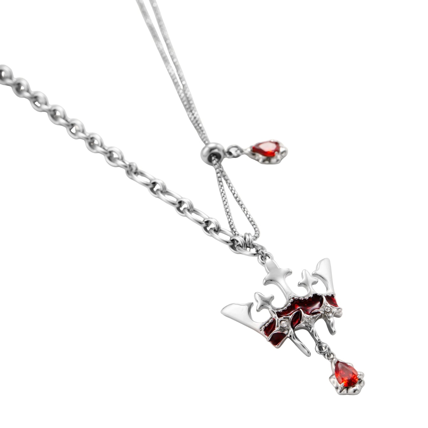 Silver-tone crown pendant with red zirconia stones and matching asymmetrical earrings on cream background