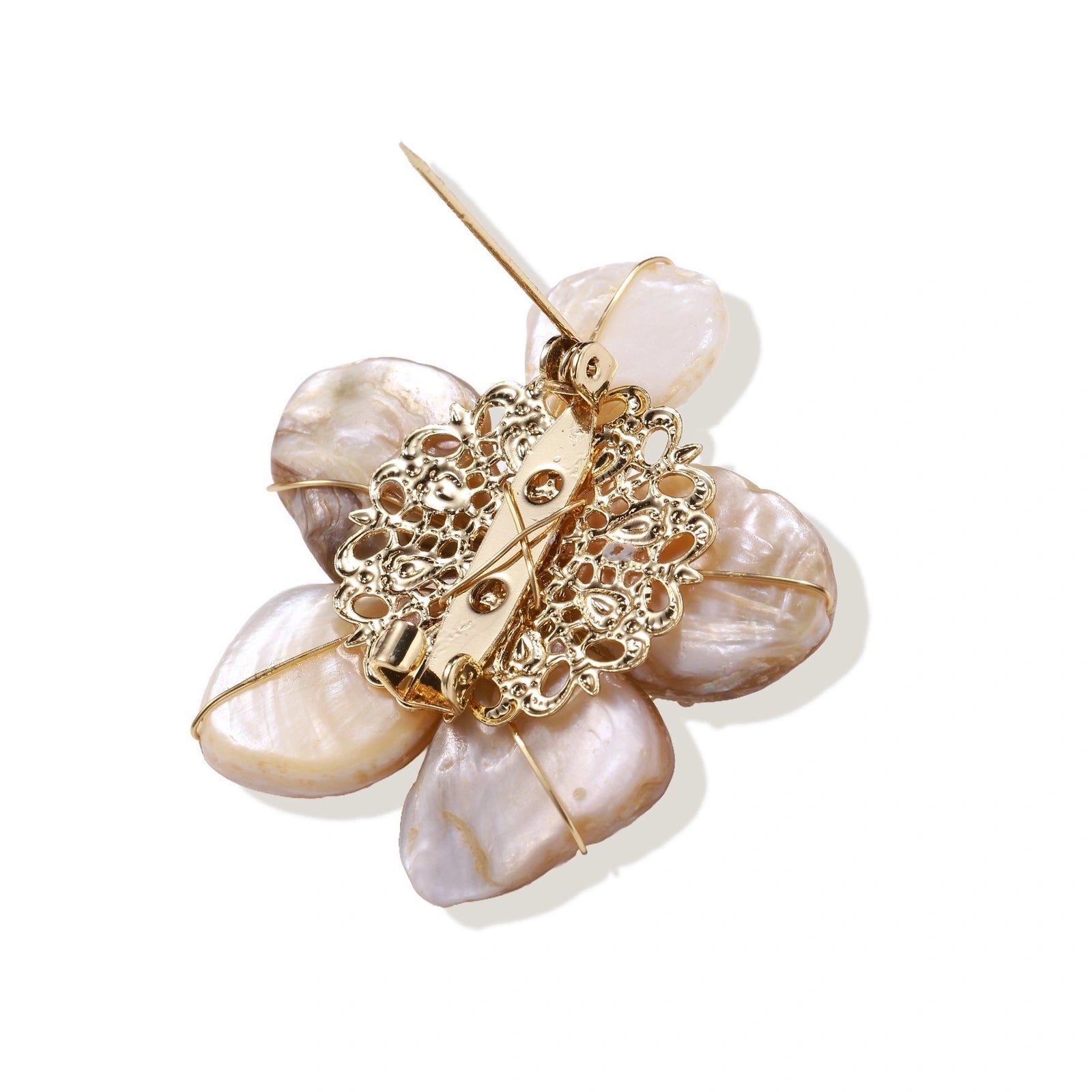 Flower-shaped brooch with iridescent shell petals, freshwater pearl center, and gold-plated radiating details.