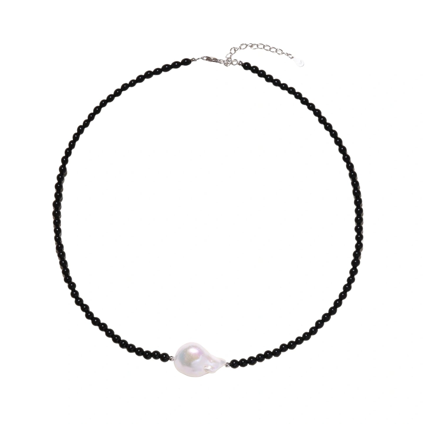 Beaded black agate necklace with iridescent baroque freshwater pearl centerpiece on cream background.