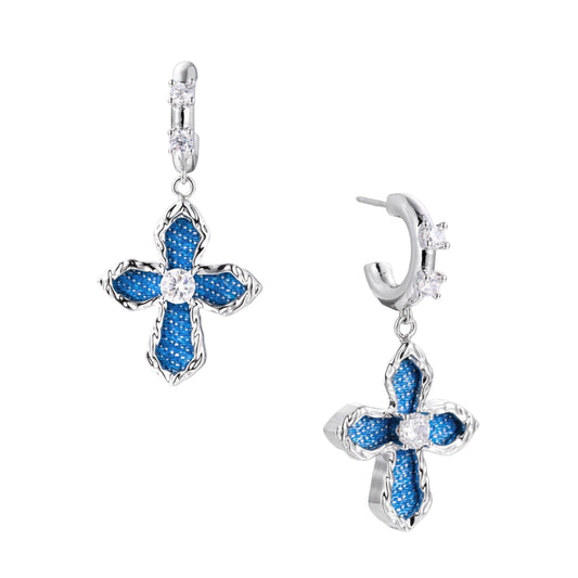 Silver hoops with denim-inlaid cross charms and clear crystals on beige background