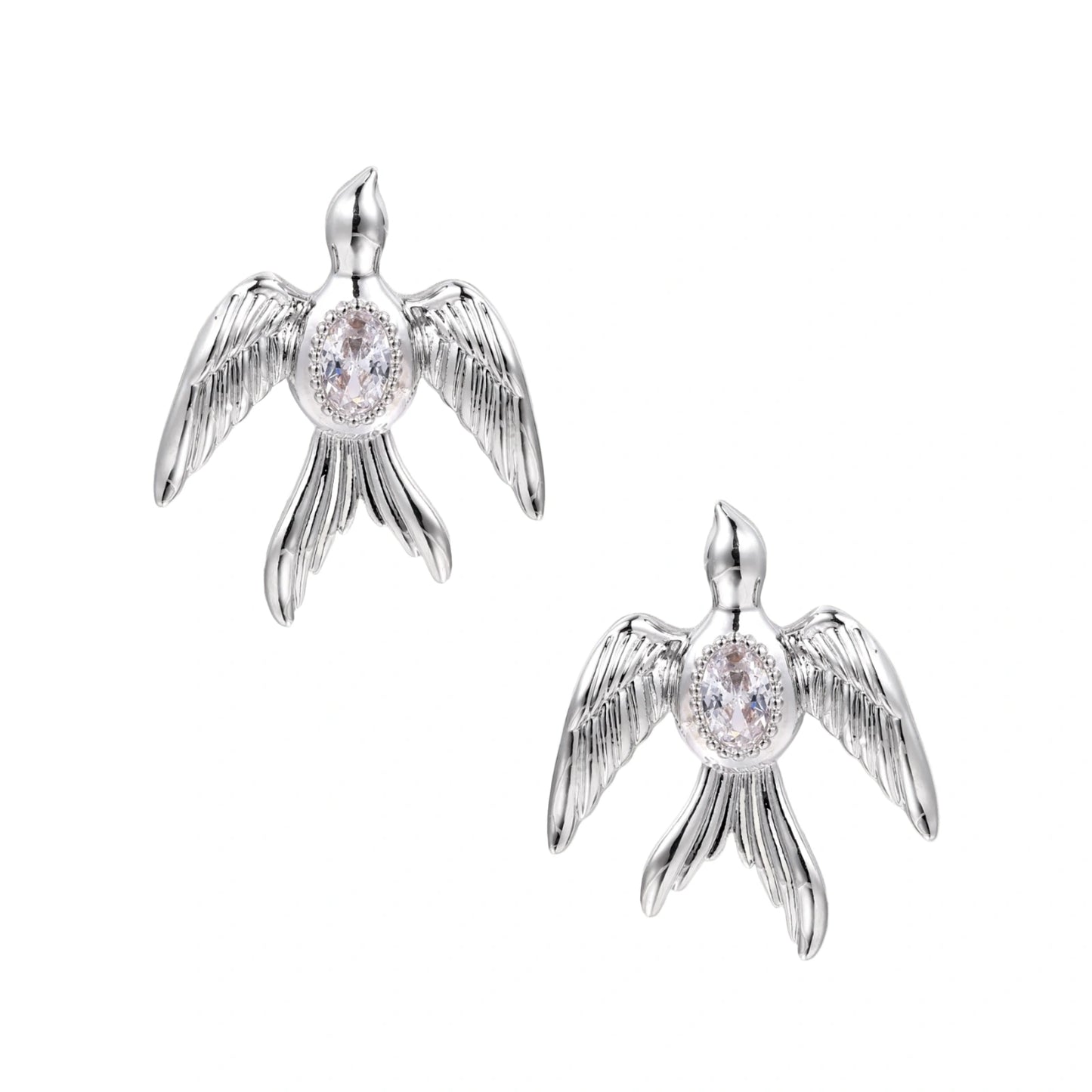 White gold-plated bird earrings with spread wings and oval zirconia center on cream background