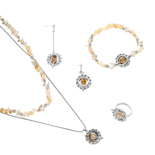 Complete jewelry set featuring citrine stone chips, silver beads, and cosmic circle pendants on cream background.