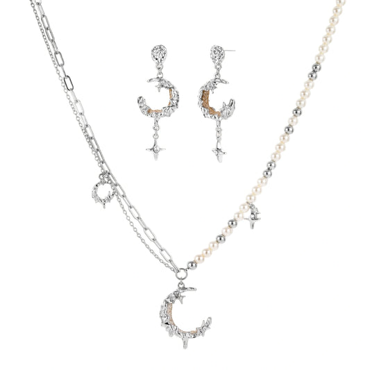 Mixed-metal jewelry set featuring layered necklaces with crescent moon pendant and pearl beads, plus matching star-drop earrings.