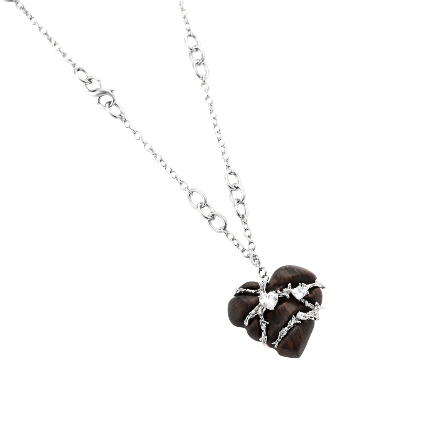 Dark ebony wood heart charms wrapped in intricate silver chains with crystal accents, shown as matching earrings and necklace set.