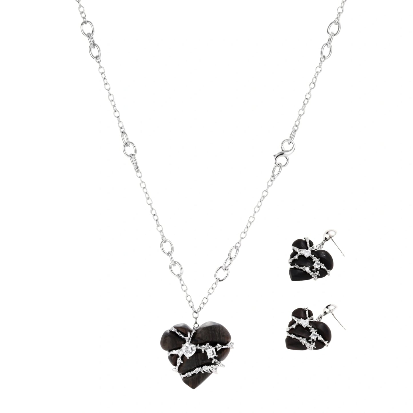 Dark ebony wood heart charms wrapped in intricate silver chains with crystal accents, shown as matching earrings and necklace set.