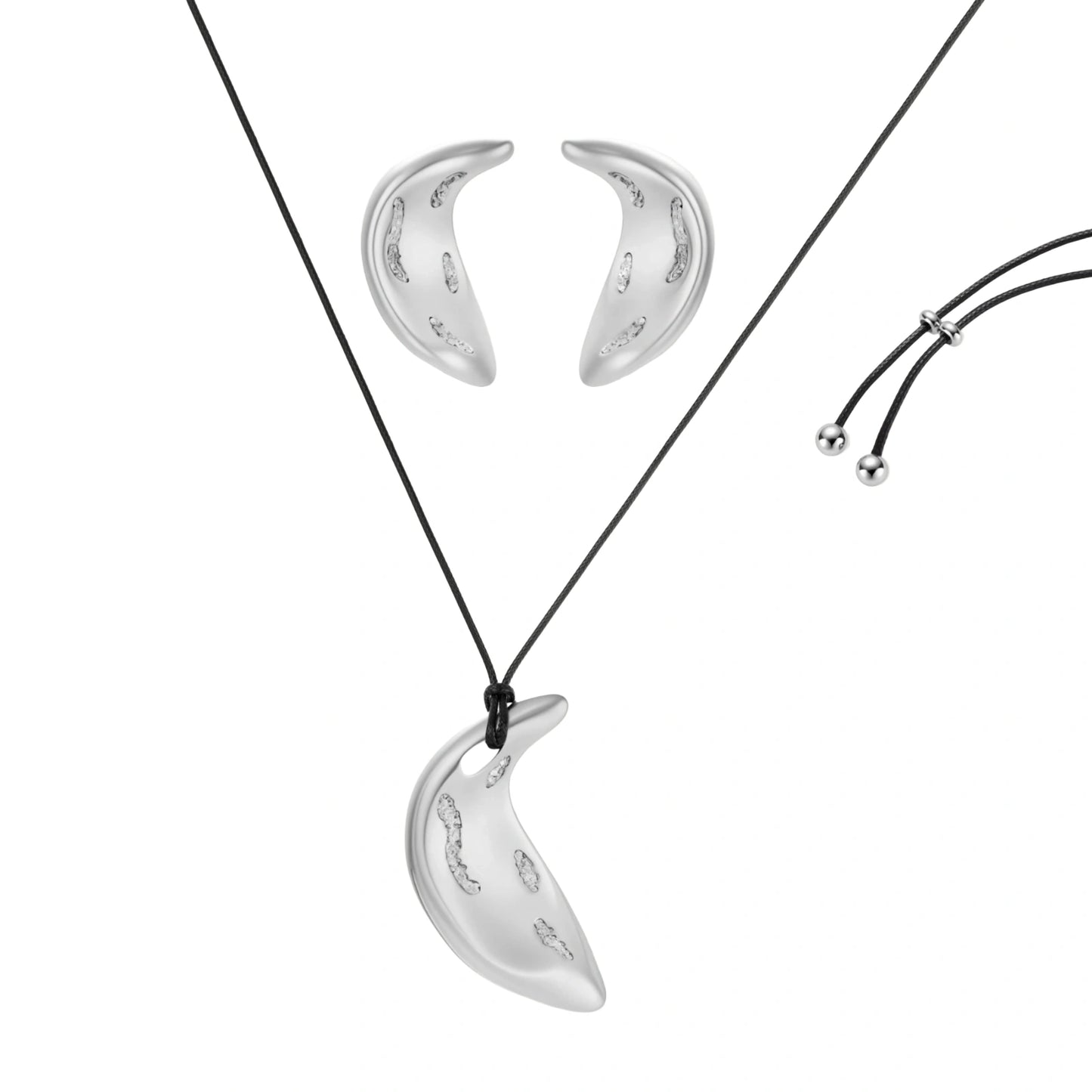 Crescent moon shaped pendant and earrings in eco-zinc alloy with curved crystal inlay patterns on light background.