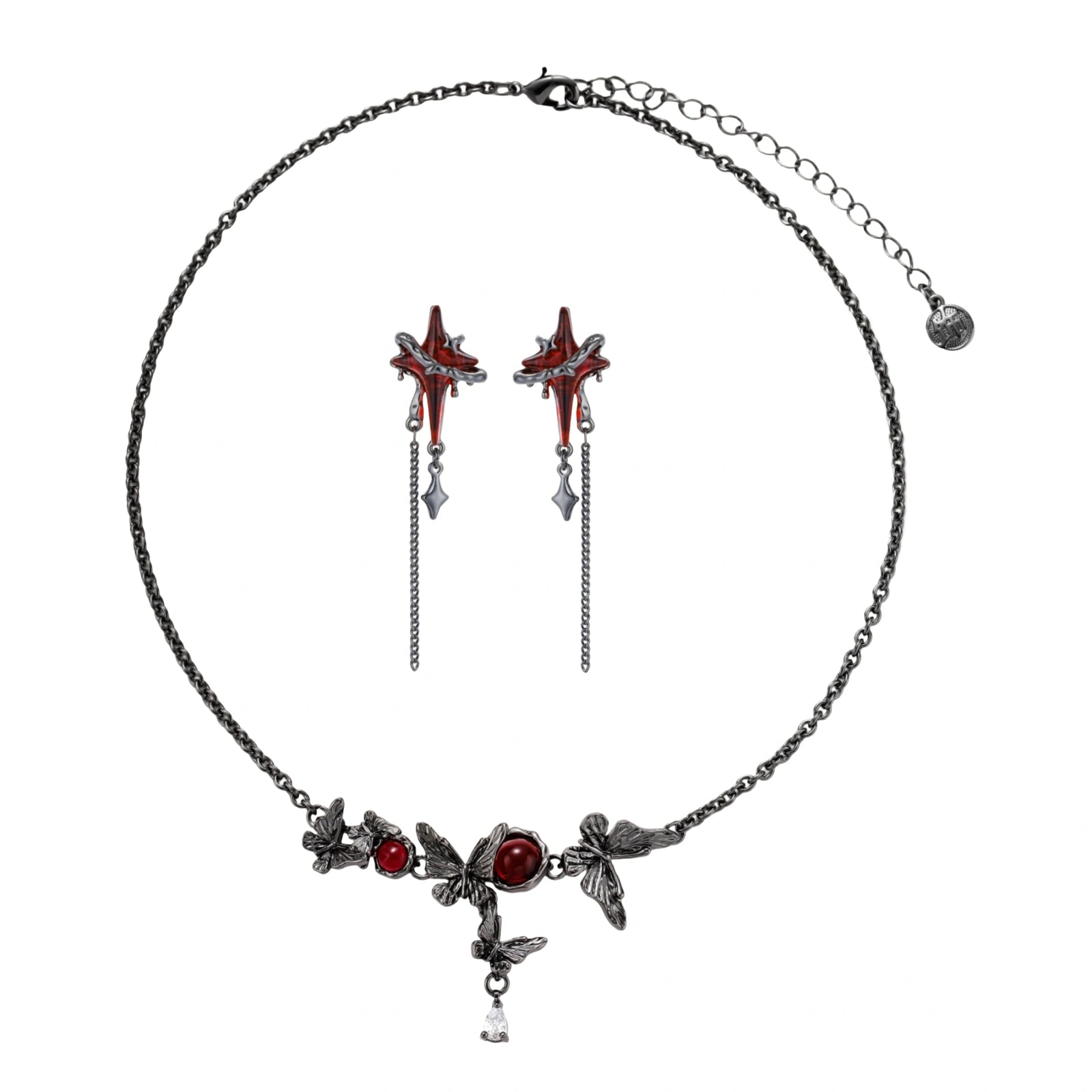 Gothic jewelry set with red resin cross pendants wrapped in dark metal chains on cream background.