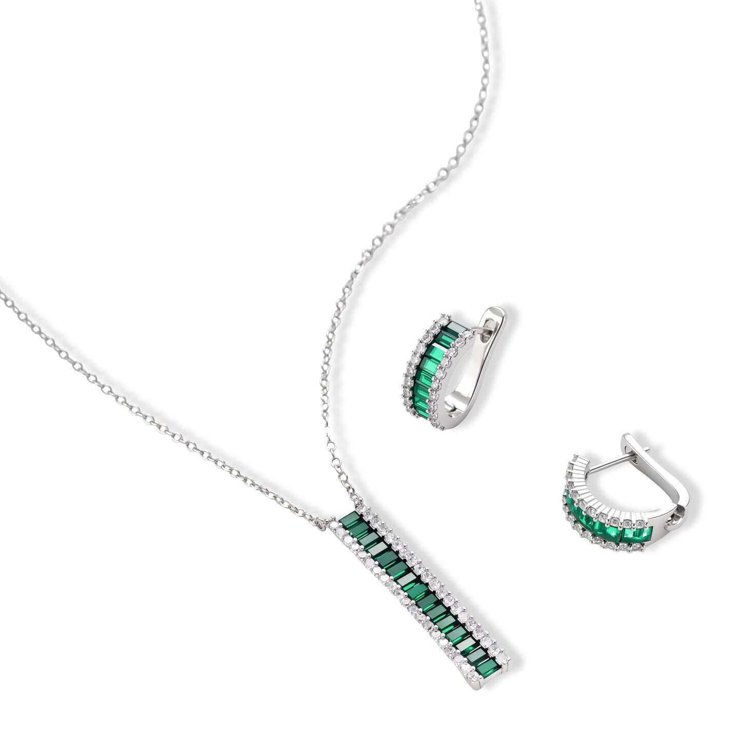White gold plated jewelry set with emerald green rectangular stones and clear crystals in geometric rows on white background.