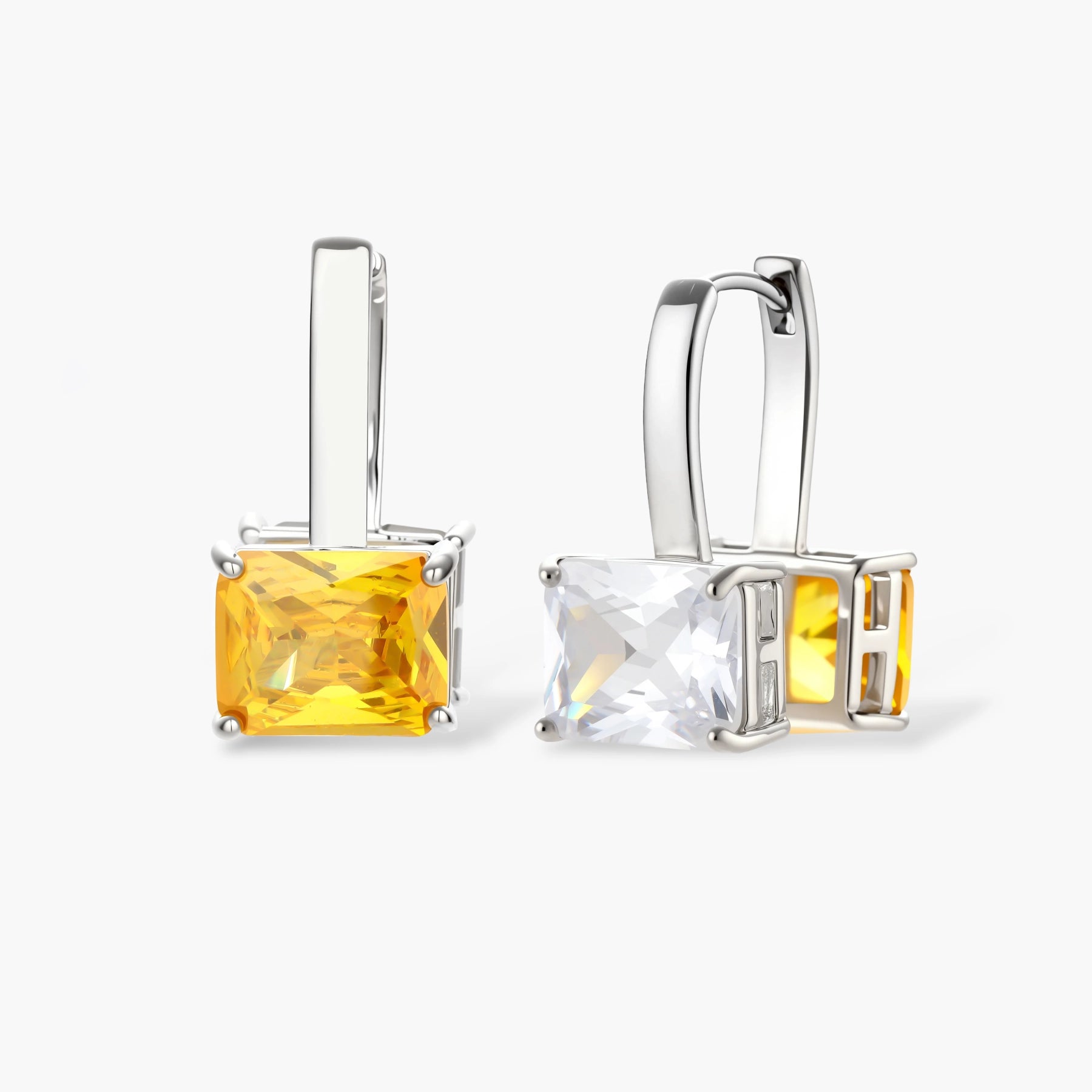 Silver curb-chain necklace and hoop drop earrings set with paired yellow and clear square zirconia stones.